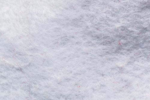 Preview: Cotton fibers arranged on a surface in a close-up view during daylight