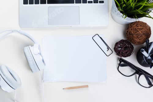 Preview: Workspace at home with laptop, headphones, and office supplies in a neat arrangement