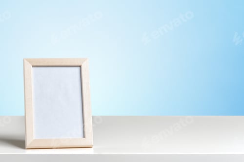 Vista previa: Marco de fotos vacío sobre un estante blanco con fondo azul listo para una foto