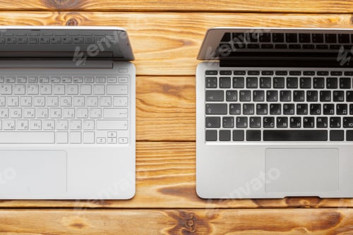 Preview: Two laptops placed on a wooden table side by side showing different keyboard designs and colors