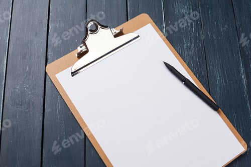 Preview: Blank clipboard with pen on wooden table ready for notes or plans at work or school