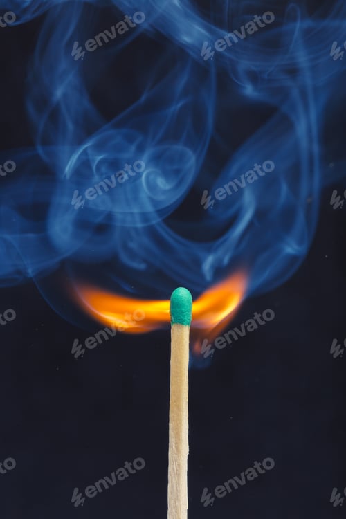 Preview: Match ignites and produces smoke in a dark setting during evening
