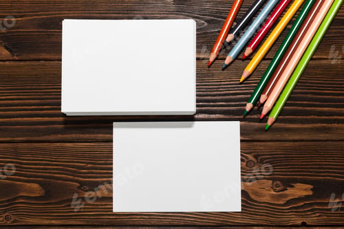 Preview: Colorful pencils and blank cards on a wooden table for creative activities