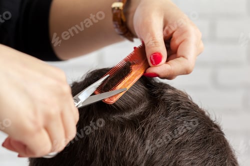 Preview: Haircut session at a salon with stylist using scissors and comb on client