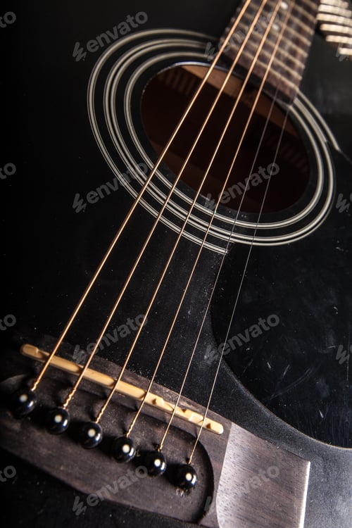 Preview: Close-up of an acoustic guitar strings and bridge showing detail and texture in a home setting