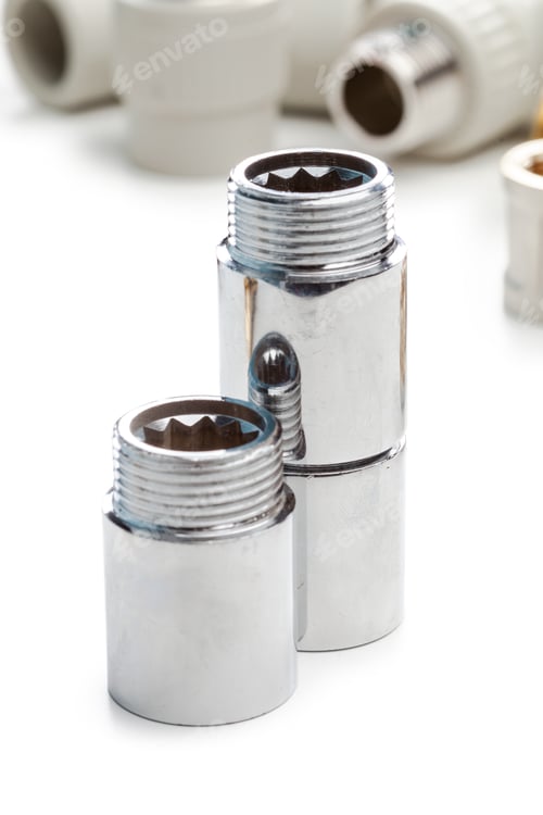 Preview: Metal plumbing fittings on a plain surface with other connectors in the background