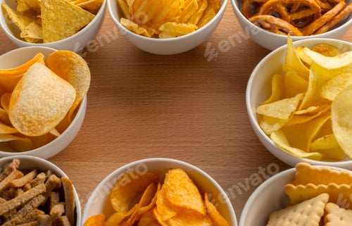 Preview: Snack bowls filled with different chips and crackers arranged on a wooden table