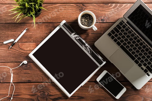 Preview: Working at a wooden desk with coffee, laptop, and stationery during morning hours