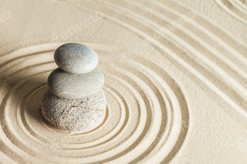 Preview: Three stones stacked on sand with circular patterns surrounding them