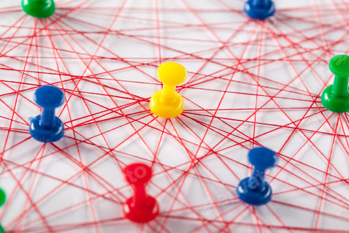 Preview: Colorful push pins and red strings create a connected pattern on white background