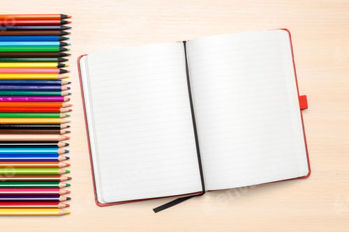 Preview: Open notebook with colored pencils on a wooden table ready for drawing and writing activities