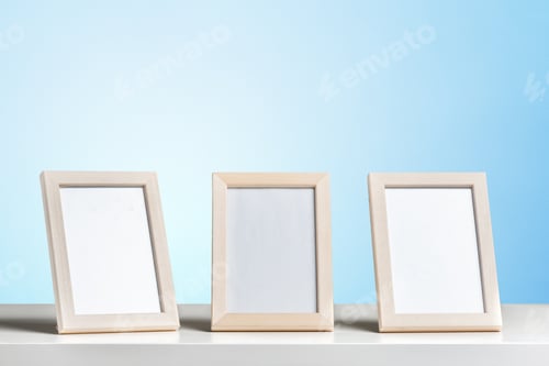 Preview: Three empty picture frames on a white shelf with a blue background