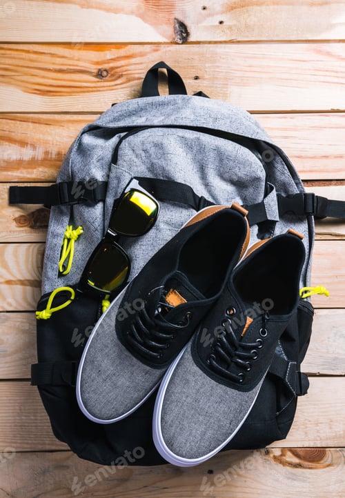Preview: Shoes and backpack on wooden table for outdoor activity preparation