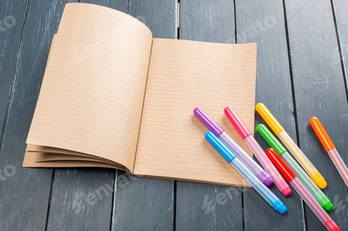 Preview: Blank notebook and colorful markers on a wooden table ready for creative work