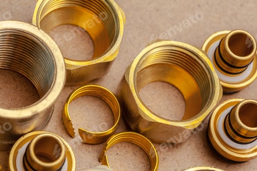 Preview: Different types of brass fittings and connectors on a work surface in a workshop
