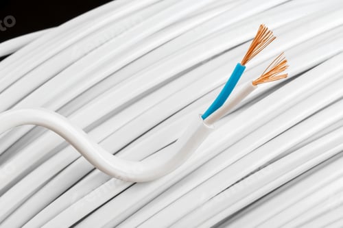 Preview: White electrical wire with exposed copper strands and blue insulation near a coil of cable