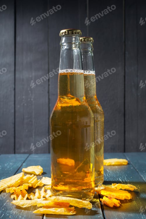 Preview: Two bottles of clear drink sit on a table with yellow snacks around them
