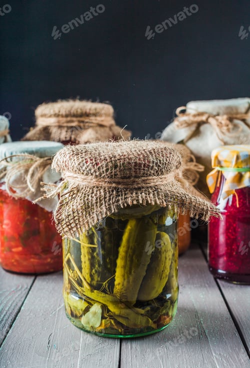 Preview: Jars of pickles and preserves displayed on a wooden table with dark background