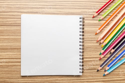Preview: Blank notebook and colored pencils on a wooden table for creative drawing