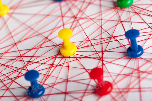 Preview: Connections of colored pins on red threads at a desk during a creative activity session