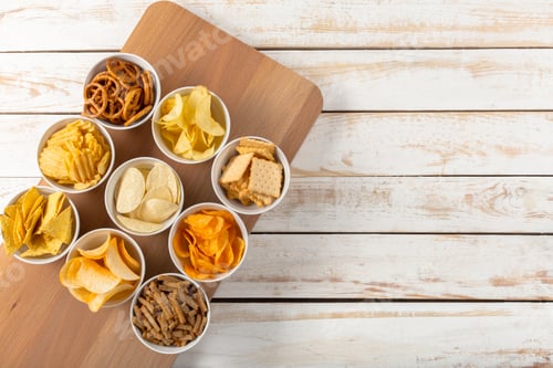 Preview: Group of snack cups on a wooden board with various chips and crackers in a kitchen setting