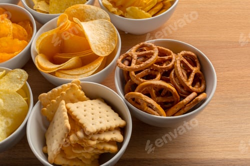 Preview: Variety of snacks served in bowls on a wooden table during a gathering