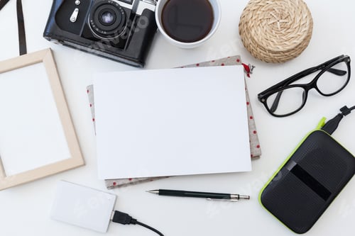 Preview: Camera, coffee, notebook, and other items arranged on a table for a creative workspace setup