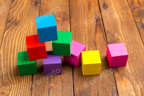 Preview: Colorful wooden blocks stacked on a wooden surface during playtime in a home