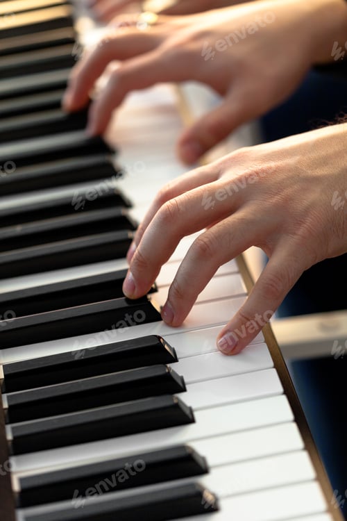 Preview: Hands play a keyboard in a music setting with natural light in the background during daytime