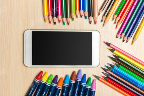 Preview: Colorful art supplies arranged around a blank smartphone on a wooden surface