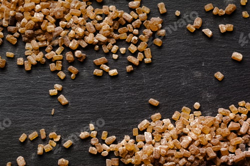 Preview: Brown sugar scattered on black surface for baking and cooking use