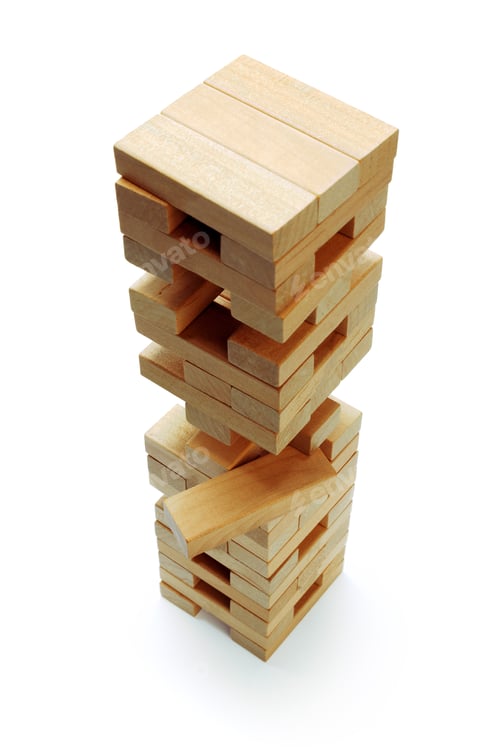 Preview: Wooden block tower stands tall with one block removed from the bottom section during a game