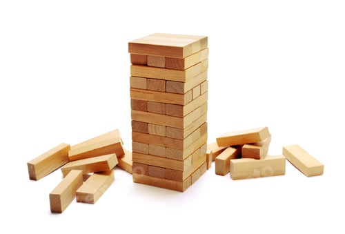 Preview: Game of skill with wooden blocks stacked on a table with scattered pieces around