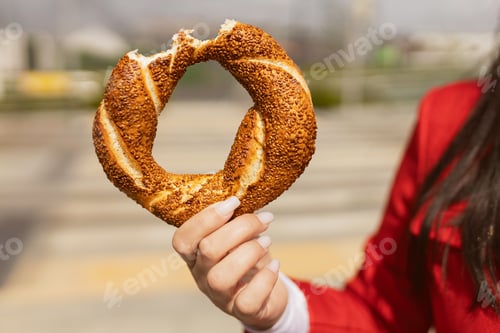 Preview: Unrecognizable woman holding traditional Turkish Simit bread with sesame seeds outdoors