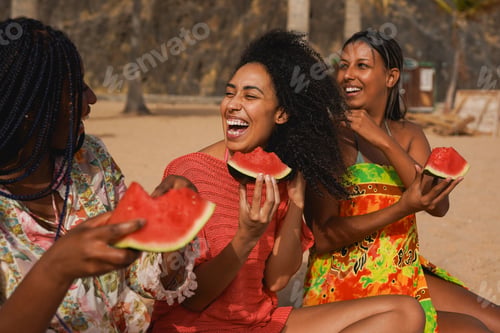 Preview: Happy multiracial girls having fun eating watermelon during summer beach vacation