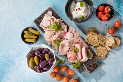 Preview: Slices Of Traditional Italian antipasti mortadella Bolognese on a wooden cutting board.