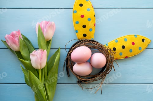 Preview: Easter eggs, fresh tulips, bunny ears on blue wooden background