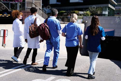 Preview: Diverse medical team walking on hospital campus