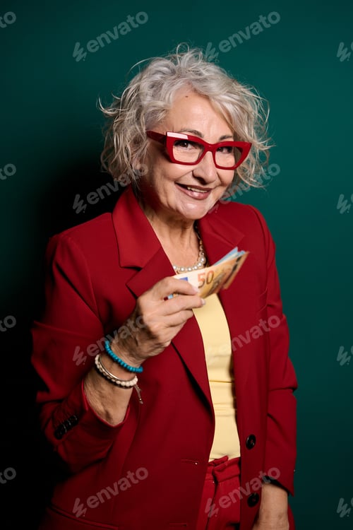 Preview: Senior woman holding euro banknotes smiling at camera