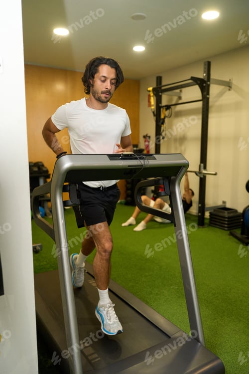 Preview: Man running on treadmill working out at gym
