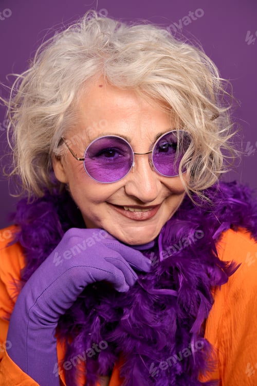 Preview: Senior woman smiling wearing vibrant purple accessories