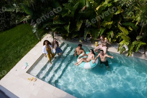 Preview: Friends enjoying summer pool party at tropical resort