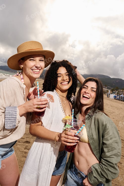 Preview: Diverse women friends enjoying cocktails on beach vacation