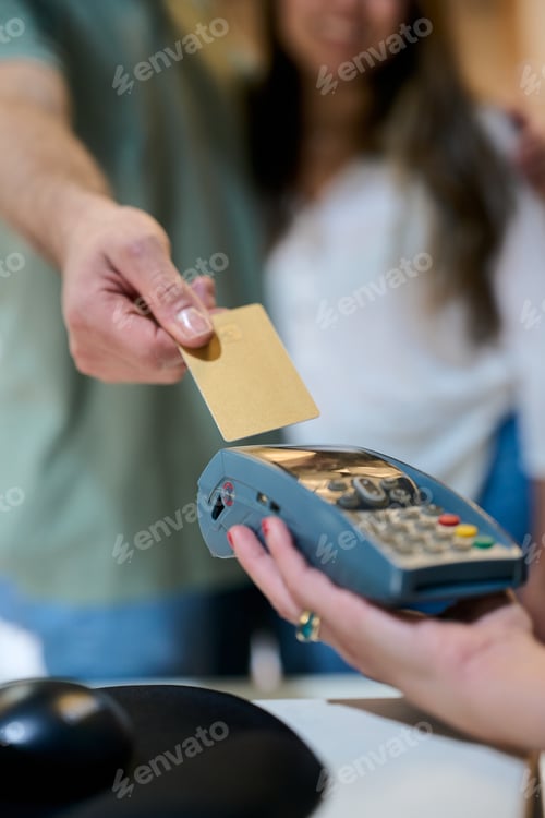Preview: Man making contactless credit card payment at pos terminal