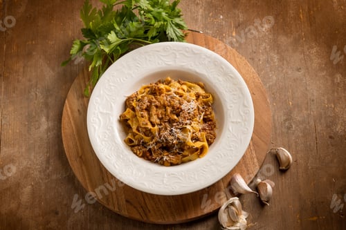 Preview: Hearty Pasta Bolognese with Fresh Parsley and Garlic on Wooden Table