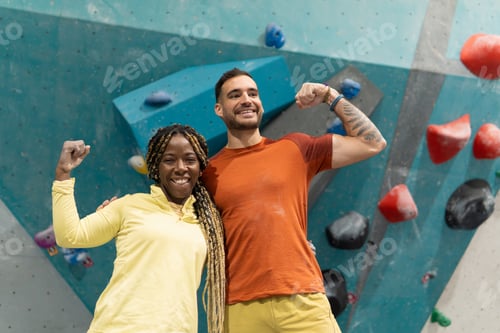 Preview: Diverse friends bouldering, showing strength and success in climbing