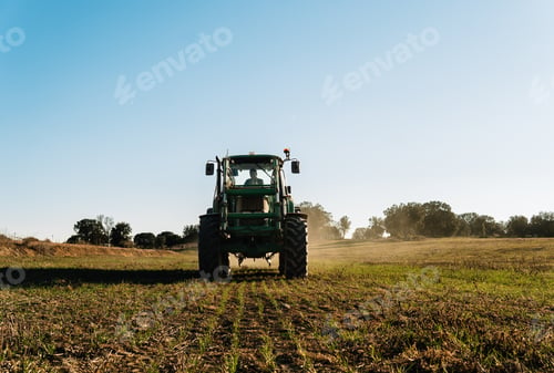Preview: Farmer driving tractor spreading fertilizer on agricultural field