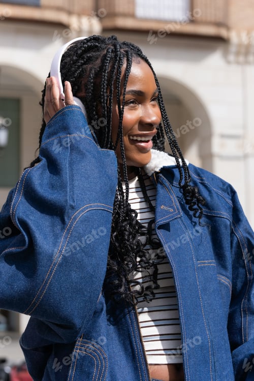 Preview: Young woman listening to music in urban setting