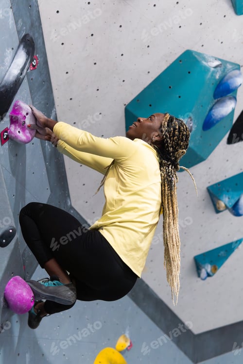 Preview: Woman bouldering indoors training strength and fitness