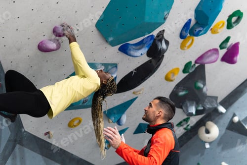 Preview: Woman and man bouldering in climbing gym